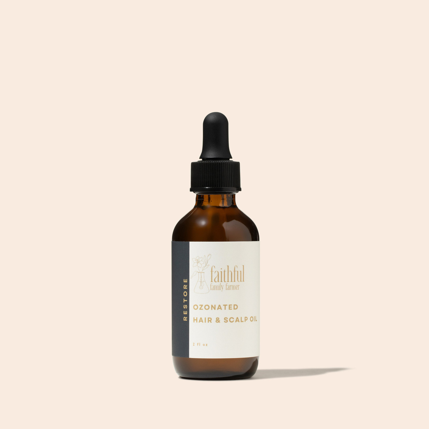 An amber glass dropper bottle of Faithful Landscaper Ozonated Hair &amp; Scalp Oil with a black dropper cap and a cream label, set against a solid pale beige background.