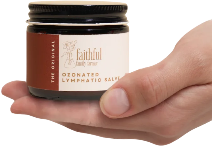 Hand holding a jar of Ozonated Lymphatic Salve